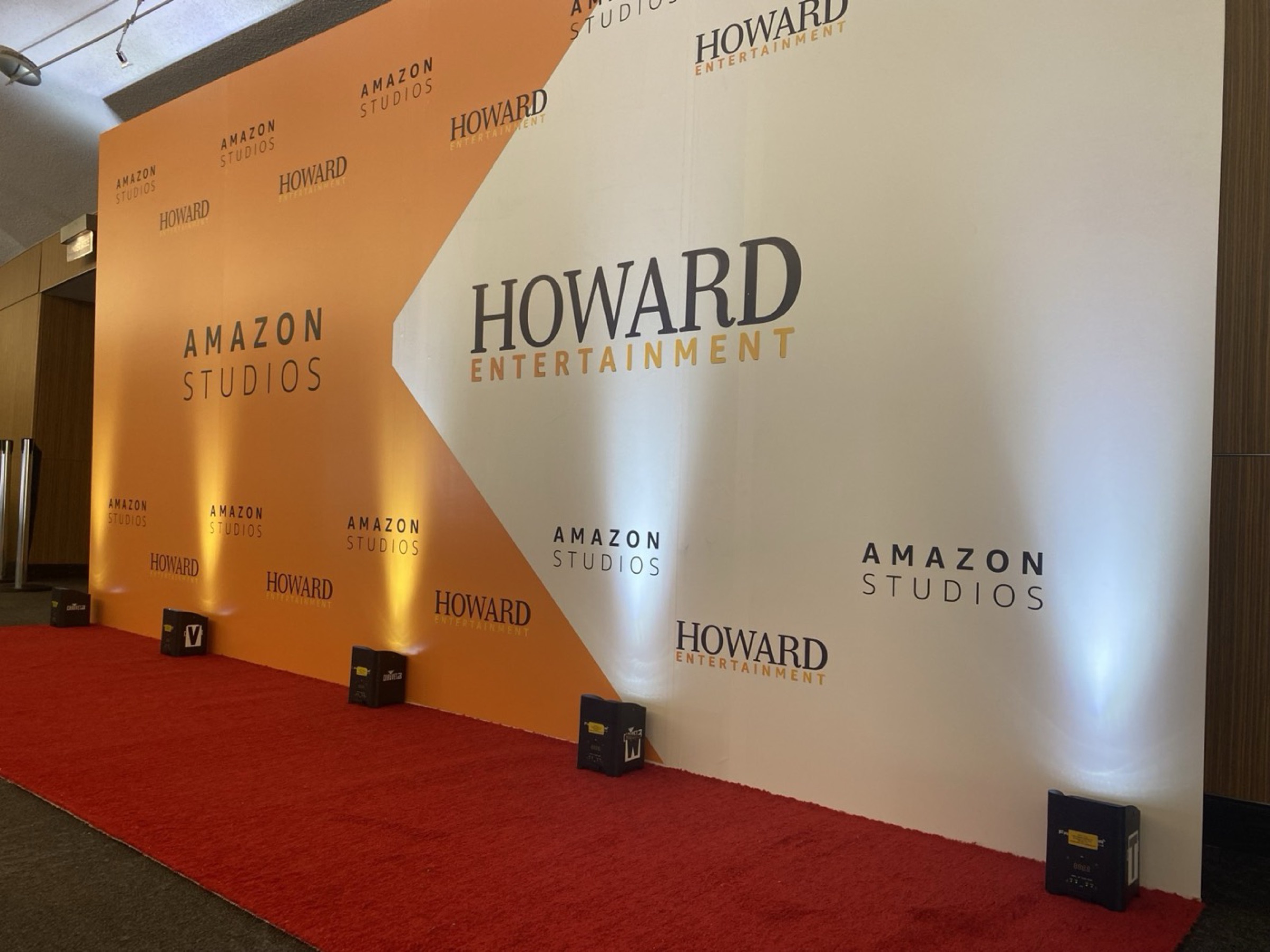 A red carpet leading to a step-and-repeat backdrop printed with the Howard Entertainment and Amazon Studios logos.